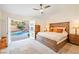 Bedroom with a large bed, side tables and double doors leading to a pool at 159 Coastal Pier Ct, Henderson, NV 89002