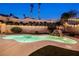 Beautiful swimming pool with a rock waterfall feature, surrounded by lush greenery and serene landscape at 159 Coastal Pier Ct, Henderson, NV 89002