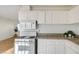 Clean, compact kitchen with white cabinets and granite counters at 1608 June Ave, North Las Vegas, NV 89032
