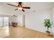 Bright living room with dining area featuring laminate floors, ceiling fans, and large windows at 1608 June Ave, North Las Vegas, NV 89032