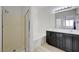 Modern bathroom with glass-enclosed shower and double sink vanity with black cabinets at 201 Crown Imperial St, Henderson, NV 89074