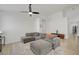 Bright living room featuring a plush gray sectional, soft rug, and modern ceiling fan at 201 Crown Imperial St, Henderson, NV 89074
