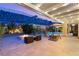 Relaxing backyard oasis with fire pit, lounge chairs, covered patio, and rock wall landscaping for added privacy at 21 Grand Masters Dr, Las Vegas, NV 89141
