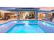 Inviting backyard pool and spa with elegant stone surround, lounge chairs, and covered patio with outdoor seating at 21 Grand Masters Dr, Las Vegas, NV 89141