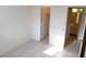 A bright bedroom features neutral tile flooring, access to the closet and bathroom at 2471 Old Forge Ln # 105, Las Vegas, NV 89121