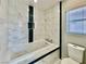 Elegant bathroom features a luxurious soaking tub with marble tile surround and a bright window at 248 Crystal Rose Ct, Las Vegas, NV 89106