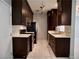 Galley kitchen featuring stainless steel appliances, dark cabinets, and marble flooring at 248 Crystal Rose Ct, Las Vegas, NV 89106