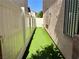 Narrow side yard with artificial turf and white fencing, providing a clean, low-maintenance outdoor space at 248 Crystal Rose Ct, Las Vegas, NV 89106