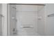 A bright white tiled shower-tub featuring a shower head and soap and shampoo storage at 3318 N Decatur Blvd # 2103, Las Vegas, NV 89130