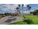 Recreation area with a sand volleyball court bordered by grass, trees, and a fence at 3318 N Decatur Blvd # 2103, Las Vegas, NV 89130