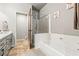 Bright bathroom features a shower over tub with glass screen, a wooden door, and gray cabinetry at 3337 Partridge Run St, Laughlin, NV 89029