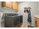 Well-equipped laundry room with updated washer and dryer units and wooden storage cabinets at 3337 Partridge Run St, Laughlin, NV 89029