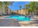 Community pool featuring clear blue water surrounded by palm trees and building exteriors under a clear sky at 4400 S Jones Blvd # 2007, Las Vegas, NV 89103