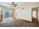 Spacious living room featuring plush carpeting, ceiling fan, neutral decor, and natural light from the glass door at 4400 S Jones Blvd # 2007, Las Vegas, NV 89103