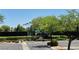 View of community tennis courts surrounded by lush greenery and trees, offering a private recreational space at 4814 Regalo Bello St, Las Vegas, NV 89135