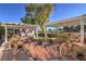 Backyard with covered patio, rock water feature, lush landscaping, and a charming garden area at 5110 N Valadez St, Las Vegas, NV 89149