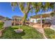 Lush backyard featuring mature trees, covered patios, a built-in grill area, and well-manicured landscaping at 5110 N Valadez St, Las Vegas, NV 89149