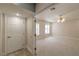 A carpeted bedroom with two windows, a ceiling fan and a door to the hallway at 5110 N Valadez St, Las Vegas, NV 89149