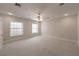 A carpeted bedroom with two windows, neutral walls and a ceiling fan with lights at 5110 N Valadez St, Las Vegas, NV 89149