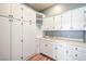 Spacious laundry room with ample storage in white cabinets and drawers, and a convenient utility sink at 5110 N Valadez St, Las Vegas, NV 89149