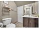 Well-lit powder room with dark wood vanity, ceramic tile floors and modern fixtures at 5308 Carlsbad Heights St, North Las Vegas, NV 89081