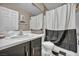 Bathroom with a shower-tub combination, black and white shower curtain, and single sink vanity at 5308 Carlsbad Heights St, North Las Vegas, NV 89081