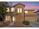 Two-story home featuring a charming front entrance, two-car garage, and low-maintenance desert landscaping at 5308 Carlsbad Heights St, North Las Vegas, NV 89081