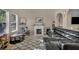 Bright living area featuring a fireplace, patterned rug, and black leather sectional sofa at 5308 Carlsbad Heights St, North Las Vegas, NV 89081