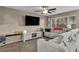 Cozy living room with plush gray sectional, ceiling fan, and large window for ample natural light at 5308 Carlsbad Heights St, North Las Vegas, NV 89081