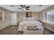 Comfortable main bedroom with plush carpeting, a ceiling fan, natural light, and a cozy bench at 5308 Carlsbad Heights St, North Las Vegas, NV 89081