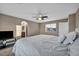 Main bedroom with plush carpeting, ceiling fan, large window, and view to the ensuite at 5308 Carlsbad Heights St, North Las Vegas, NV 89081