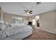 Spacious main bedroom featuring plush carpeting, a ceiling fan, and a view into the attached bathroom at 5308 Carlsbad Heights St, North Las Vegas, NV 89081