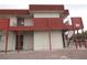 Exterior view of building featuring access stairs, upper balcony, neutral paint, and red accent trim at 5388 Swenson St # 26, Las Vegas, NV 89119