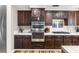 Kitchen featuring stainless steel oven, gas cooktop, dark cabinets, and tiled countertops at 5452 Desert Spring Rd, Las Vegas, NV 89149