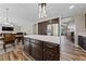 Kitchen island with tile countertop in open concept with stainless appliances and dark wood cabinets at 5452 Desert Spring Rd, Las Vegas, NV 89149