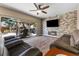A stylish living room with a brick wall, fireplace, and sliding glass doors to the backyard at 5452 Desert Spring Rd, Las Vegas, NV 89149