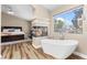 An open main bedroom featuring a fireplace, garden tub, and large window at 5452 Desert Spring Rd, Las Vegas, NV 89149