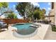 Inviting backyard pool with an attached jacuzzi, patio furniture, and lush landscaping at 5452 Desert Spring Rd, Las Vegas, NV 89149