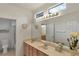 Bathroom featuring double sinks, a large mirror, and stylish lighting fixtures at 585 Mountain Links Dr, Henderson, NV 89012
