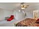 Large bedroom with sitting area, chair, red ottoman, and neutral walls at 585 Mountain Links Dr, Henderson, NV 89012