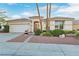 Charming single-story home with desert landscaping, mature palm trees and attached two-car garage at 585 Mountain Links Dr, Henderson, NV 89012