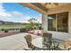 Covered patio with seating area overlooks the landscaped yard and golf course at 585 Mountain Links Dr, Henderson, NV 89012