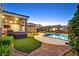 This backyard boasts a sparkling pool, manicured lawn, outdoor seating, and a covered patio at 6208 W Rome Blvd, Las Vegas, NV 89131