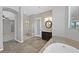 Bright bathroom showcasing tile floors, dual vanities, a glass-enclosed shower, and a luxurious soaking tub at 6208 W Rome Blvd, Las Vegas, NV 89131