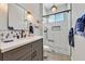 Modern bathroom features marble vanity, glass enclosed shower, modern fixtures, and a decorative mirror at 6208 W Rome Blvd, Las Vegas, NV 89131