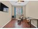 Cozy bedroom featuring a rocker, small desk, hardwood floors, and a bright window at 6208 W Rome Blvd, Las Vegas, NV 89131