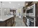 Open-concept kitchen featuring stainless steel appliances, granite counters, and dark wood cabinetry at 6208 W Rome Blvd, Las Vegas, NV 89131