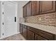 Pantry space with granite countertops, tile backsplash, and sleek brown cabinets at 6208 W Rome Blvd, Las Vegas, NV 89131