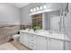 Bright bathroom with double sink vanity, white cabinets, and large mirror at 6635 Caporetto Ln # 204, North Las Vegas, NV 89084