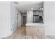 Open-concept kitchen with modern gray cabinets, tile backsplash, breakfast bar with quartz countertops, and wood flooring at 6635 Caporetto Ln # 204, North Las Vegas, NV 89084